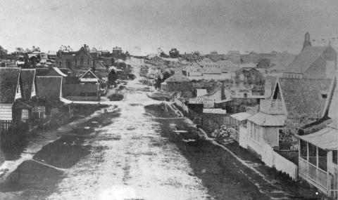 View of Adelaide Street, Brisbane taken in 1860 showing a dirt street and wooden houses