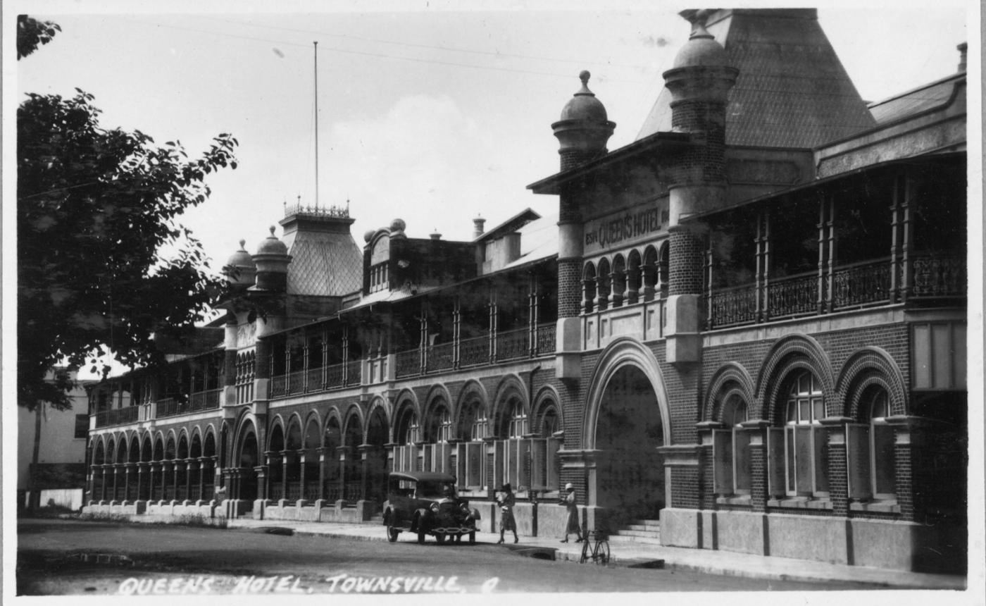 View of Queens Hotel, Townsville, featuring car and patrons. 